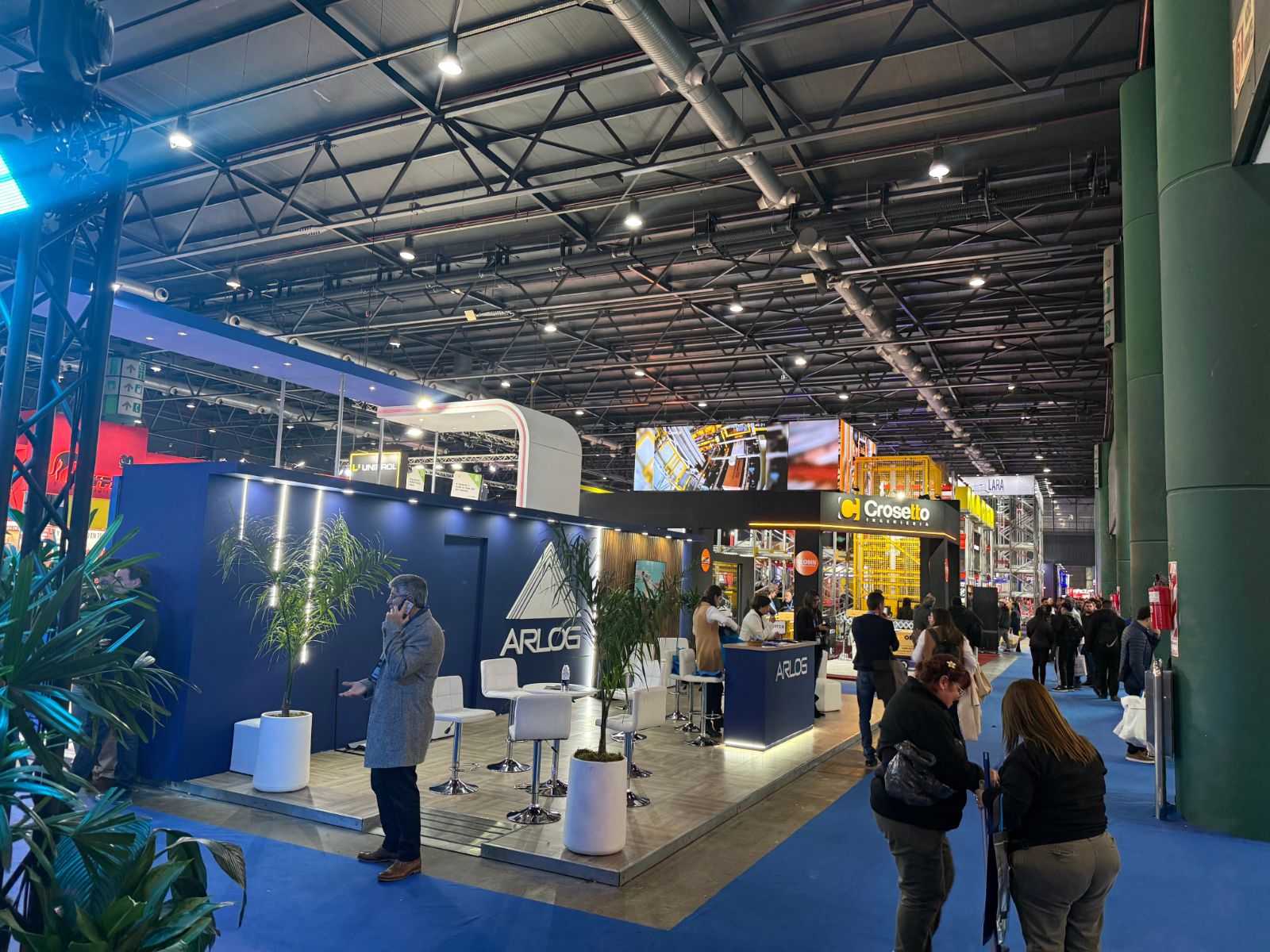 Stand con isla de atención y personal recibiendo visitantes
